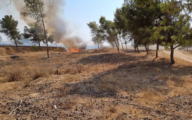 Firefighters try to extinguish a blaze in southern Israel that was sparked by a ballon-borne incendiary device launched by Palestinians in the Gaza Strip, on August 6, 2021. (Moshe Baruchi/KKL-JNF) Firefighters try to extinguish a blaze in southern Israel that was sparked by a ballon-borne incendiary device launched by Palestinians in the Gaza Strip, on August 6, 2021. (Moshe Baruchi/KKL-JNF)