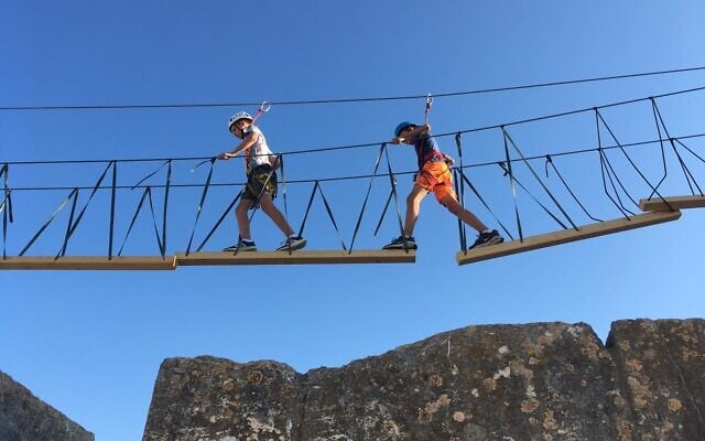 Walking across a hanging bridge in the Tower of David Museum ropes course, August 2021 (Jessica Steinberg/Times of Israel) Walking across a hanging bridge in the Tower of David Museum ropes course, August 2021 (Jessica Steinberg/Times of Israel)