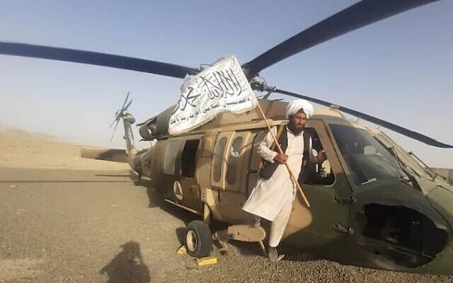 A Taliban member poses atop a US US-60 Black Hawk helicopter in Afghanistan, August 2021. (Uncredited) A Taliban member poses atop a US US-60 Black Hawk helicopter in Afghanistan, August 2021. (Uncredited)