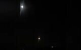 An air defense missile, bottom center, streaks toward what appears to be a missile shot into Syria, in a video distributed by Syrian state news. (Screen capture: YouTube/SANA)