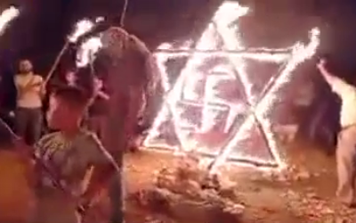 Palestinians set fire to a structure in the shape of a Star of David and a swastika near the town of Beita in the West Bank, on August 14. 2021. (Video screenshot) Palestinians set fire to a structure in the shape of a Star of David and a swastika near the town of Beita in the West Bank, on August 14. 2021. (Video screenshot)