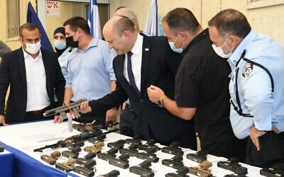 Prime Minister Naftali Bennett (center) visits a police station on August 11, 2021, to announce a new national plan to tackle crime in the Arab sector. (Amos Ben-Gershom/GPO)