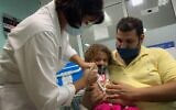 Pedro Montano holds his daughter Roxana Montano, 3, while she is being vaccinated against COVID-19 with Cuban vaccine Soberana Plus, on August 24, 2021 at Juan Manuel Marquez hospital in Havana, as part of a vaccine study in children and adolescents. (ADALBERTO ROQUE / AFP)