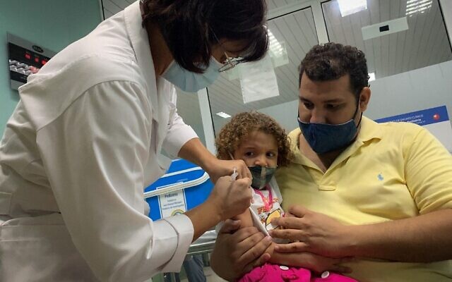 Pedro Montano holds his daughter Roxana Montano, 3, while she is being vaccinated against COVID-19 with Cuban vaccine Soberana Plus, on August 24, 2021 at Juan Manuel Marquez hospital in Havana, as part of a vaccine study in children and adolescents. (ADALBERTO ROQUE / AFP) Pedro Montano holds his daughter Roxana Montano, 3, while she is being vaccinated against COVID-19 with Cuban vaccine Soberana Plus, on August 24, 2021 at Juan Manuel Marquez hospital in Havana, as part of a vaccine study in children and adolescents. (ADALBERTO ROQUE / AFP)