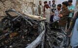 Afghan residents and family members of the victims gather next to a damaged vehicle inside a house, day after a US drone airstrike in Kabul on August 30, 2021. (WAKIL KOHSAR / AFP)