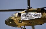 A helicopter displaying a Taliban flag fly above of supporters gathered to celebrate the US withdrawal of all its troops out of Afghanistan, in Kandahar on September 1, 2021. (JAVED TANVEER / AFP)
