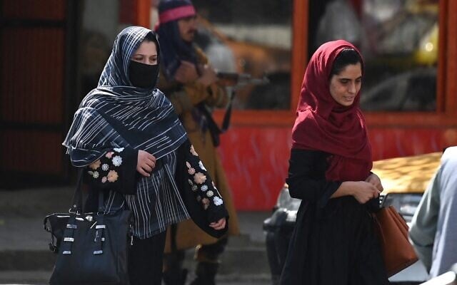 Afghan women walk past a Taliban fighter along a street in Kabul on September 2, 2021. (Aamir QURESHI / AFP) Afghan women walk past a Taliban fighter along a street in Kabul on September 2, 2021. (Aamir QURESHI / AFP)