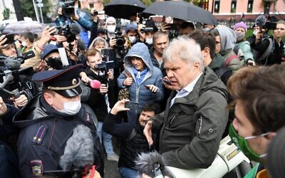 Deputy of the Moscow City Duma Sergei Mitrokhin (R) speaks with a police officer, during a demonstration called to protest against the creation of the status of "foreign agent" imposed to several independent and opposition media, in central Moscow, on September 4, 2021. (Natalia KOLESNIKOVA / AFP)
