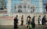 Afghan workers walk past a wall mural along a roadside in Kabul on September 5, 2021. (HOSHANG HASHIMI / AFP)