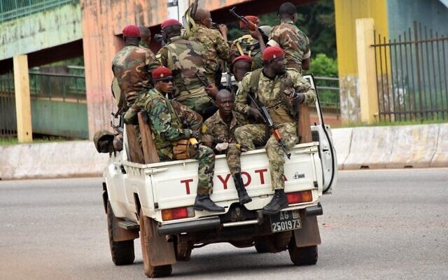Members of the Guinean armed forces drive through the central neighborhood of Kaloum in Conakry on September 5, 2021, after sustained gunfire was heard. (Cellou Binani/AFP) Members of the Guinean armed forces drive through the central neighborhood of Kaloum in Conakry on September 5, 2021, after sustained gunfire was heard. (Cellou Binani/AFP)