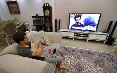 A young man watches an episode of the Iranian television series "Gando" at his home in Iran's capital Tehran on September 6, 2021. (Atta Kenare/AFP)