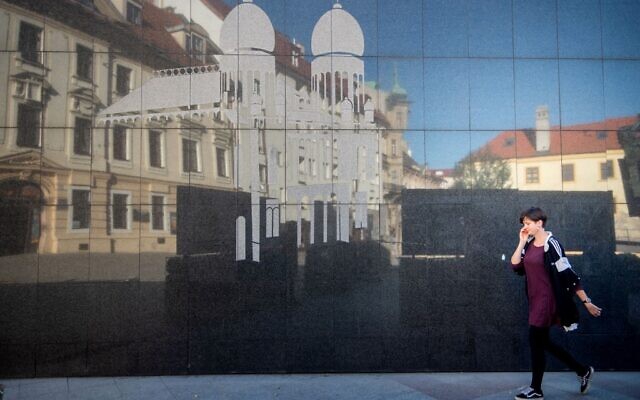 A woman passes a wall with an image of the former Neolog Synagogue next to the Holocaust Memorial located in the center of Bratislava's Old Town on September 9, 2021.(VLADIMIR SIMICEK / AFP) A woman passes a wall with an image of the former Neolog Synagogue next to the Holocaust Memorial located in the center of Bratislava's Old Town on September 9, 2021.(VLADIMIR SIMICEK / AFP)