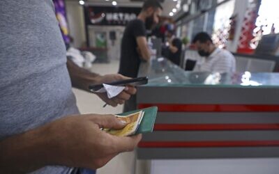 A Palestinian man receives financial aid at a supermarket in Gaza City, on September 15, 2021, as part of the UN's Humanitarian Cash Assistance program, supported by the state of Qatar. (Mahmud Hams/AFP) A Palestinian man receives financial aid at a supermarket in Gaza City, on September 15, 2021, as part of the UN's Humanitarian Cash Assistance program, supported by the state of Qatar. (Mahmud Hams/AFP)