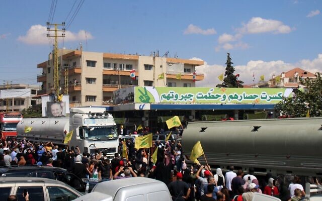 People raise an Iranian flag, as they gather to welcome tankers carrying Iranian fuel, upon their arrival from Syria in the city of Baalbeck, in Lebanon's Bekaa valley, on September 16, 2021. (AFP) People raise an Iranian flag, as they gather to welcome tankers carrying Iranian fuel, upon their arrival from Syria in the city of Baalbeck, in Lebanon's Bekaa valley, on September 16, 2021. (AFP)