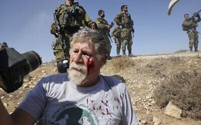 Israeli activist Eli Ziv, from the Combatants for Peace movement, lies injured on the floor after he was pushed by an Israeli soldier during a demonstration in the southern area of the West Bank town of Hebron, on September 17, 2021. (HAZEM BADER / AFP)