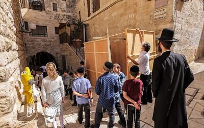 Jewish residents set up a Sukkah, a temporary hut constructed to be used during the week-long Jewish festival of Sukkot, the feast of the Tabernacles, in the old city of Jerusalem on September 20, 2021  (Emmanuel DUNAND / AFP)
