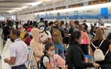 In this file photo travellers line up at Miami International Airport (MIA) on August 2, 2021.  (Photo by Daniel SLIM / AFP)