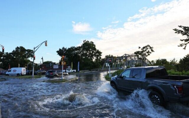 A pick-up truck drives through a flooded River Drive as water gushes out of a man hole, on September 2, 2021, in Passaic, New Jersey. (Michael M. Santiago/Getty Images/AFP) A pick-up truck drives through a flooded River Drive as water gushes out of a man hole, on September 2, 2021, in Passaic, New Jersey. (Michael M. Santiago/Getty Images/AFP)