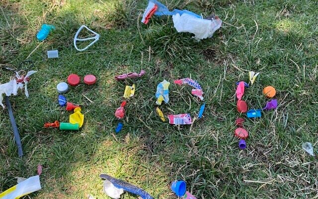 The word 'stop' spelled out in litter by Tel Aviv volunteers of Tuesdays for Trash, August 24, 2021. (Courtesy)