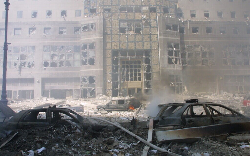 Rubble-buried cars and a destroyed building in the aftermath of the September 11 attacks.(AP Photo/Shawn Baldwin)