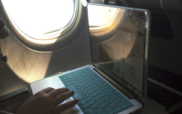 Illustrative: A passenger uses a laptop aboard a commercial airline flight from Boston to Atlanta, July 2017. (AP Photo/Bill Sikes) Illustrative: A passenger uses a laptop aboard a commercial airline flight from Boston to Atlanta, July 2017. (AP Photo/Bill Sikes)