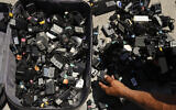 A man looks for a charger for his phone from a suitcase full of used chargers for sale in Los Angeles, on August 1, 2018. (AP Photo/Jae C. Hong)
