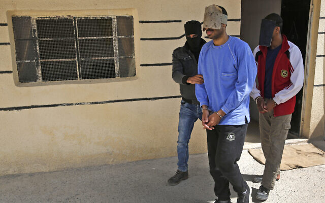 File - A Kurdish security officer escorts Alexanda Kotey, one of the Islamic State 'Beatles,' at a security center in Kobani, Syria, March 30, 2018. (AP/Hussein Malla) File - A Kurdish security officer escorts Alexanda Kotey, one of the Islamic State 'Beatles,' at a security center in Kobani, Syria, March 30, 2018. (AP/Hussein Malla)