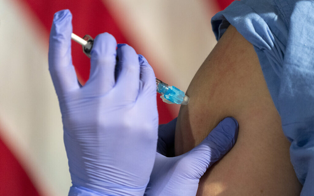 Illustrative image: In front of an American flag, nurse Lillian Wirpsza (left) administers a COVID-19 vaccine to Shylee Stewart, a labor and delivery nurse at George Washington University Hospital. (AP Photo/Jacquelyn Martin, Pool) Illustrative image: In front of an American flag, nurse Lillian Wirpsza (left) administers a COVID-19 vaccine to Shylee Stewart, a labor and delivery nurse at George Washington University Hospital. (AP Photo/Jacquelyn Martin, Pool)