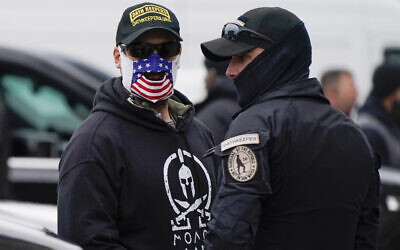 People wearing hats and patches indicating they are part of Oath Keepers attend a rally at Freedom Plaza, on January 5, 2021, in Washington, DC, in support of then-US President Donald Trump. (AP Photo/Jacquelyn Martin)