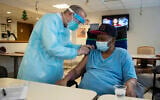 In this Jan. 15, 2021, file photo,  a pharmacist administers a COVID-19 vaccine to a nursing home resident at Harlem Center for Nursing and Rehabilitation, New York (AP Photo/Yuki Iwamura, File)
