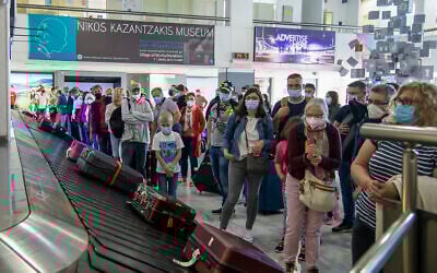 Passengers wait to pick their luggage at Nikos Kazantzakis International Airport in Heraklion, on the island of Crete, Greece, May 14, 2021. (AP Photo/Harry Nakos, File)