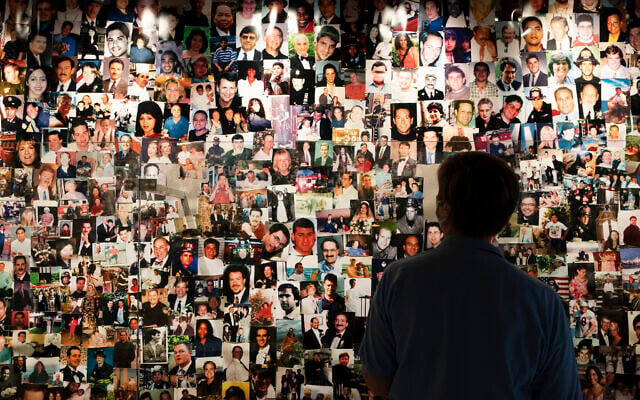 Désirée Bouchat, a survivor of the 9/11 attacks on the World Trade Center, looks at photos of those who perished, in a display at the 9/11 Tribute Museum, on Friday, August 6, 2021, in New York. (AP Photo/Mark Lennihan)