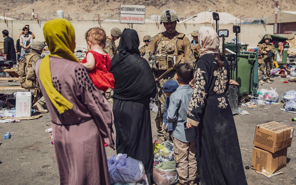 In this image provided by the US Marine Corps, Marines with the 24th Marine Expeditionary Unit process evacuees as they go through the evacuation control center at Hamid Karzai International Airport in Kabul, Afghanistan, August 28, 2021. (Staff Sgt. Victor Mancilla/U.S. Marine Corps via AP)