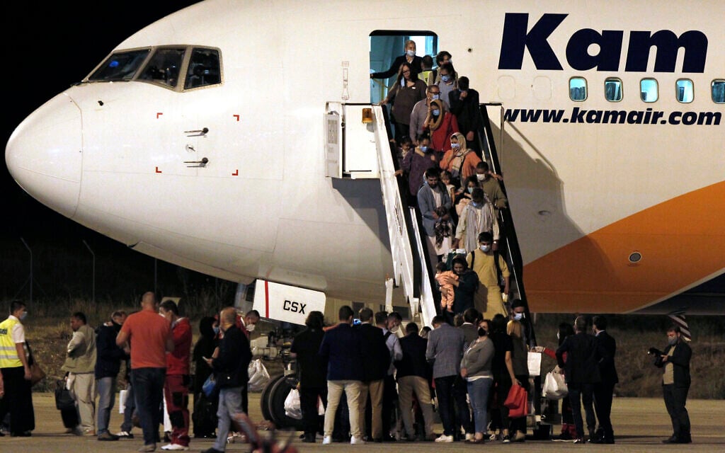 Afghan evacuees disembark from a plane after landing at Skopje International Airport, North Macedonia, August 30, 2021. (AP Photo/Boris Grdanoski)