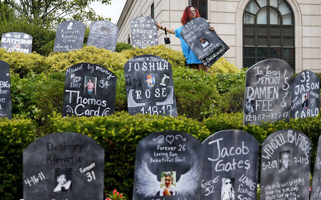 In this Aug. 9, 2021, file photo, Jayde Newton helps to set up cardboard gravestones with the names of victims of opioid abuse outside the courthouse where the Purdue Pharma bankruptcy is taking place in White Plains, N.Y. A federal bankruptcy judge on Wednesday, Sept. 1, gave conditional approval to a sweeping, potentially $10 billion plan submitted by OxyContin maker Purdue Pharma to settle a mountain of lawsuits over its role in the opioid crisis that has killed a half-million Americans over the past two decades. (AP Photo/Seth Wenig, File) In this Aug. 9, 2021, file photo, Jayde Newton helps to set up cardboard gravestones with the names of victims of opioid abuse outside the courthouse where the Purdue Pharma bankruptcy is taking place in White Plains, N.Y. A federal bankruptcy judge on Wednesday, Sept. 1, gave conditional approval to a sweeping, potentially $10 billion plan submitted by OxyContin maker Purdue Pharma to settle a mountain of lawsuits over its role in the opioid crisis that has killed a half-million Americans over the past two decades. (AP Photo/Seth Wenig, File)