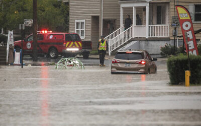 A car is stranded on a flooded street September 1, 2021, in Bridgeville, Pennsylvania. (Andrew Rush/Pittsburgh Post-Gazette via AP)