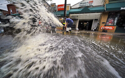 Water is pumped from the basement of a business on Noblestown road in Oakdale, Pennsylvania, during clean up from flooding after downpours and high winds from the remnants of Hurricane Ida hit the area September 1, 2021. (AP Photo/Gene J. Puskar)