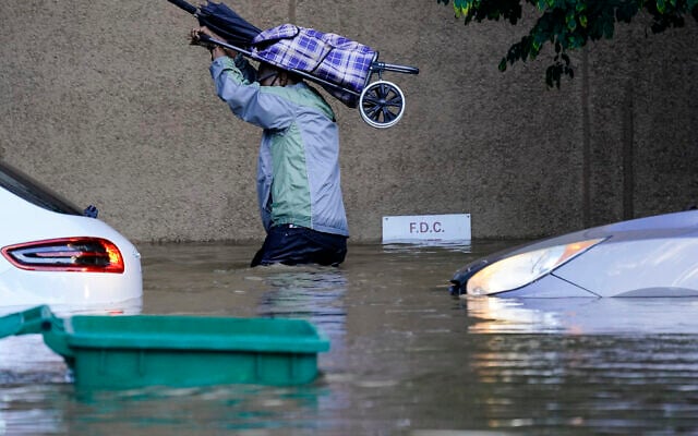 A person walks in floodwaters in Philadelphia, on Thursday, September 2, 2021, in the aftermath of downpours and high winds from the remnants of Hurricane Ida that hit the area. (AP Photo/Matt Rourke)