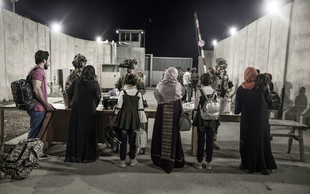 In this August 25, 2021 file image provided by the US Marine Corps, soldiers with the 82nd Airborne Division check evacuees during an evacuation at Hamid Karzai International Airport in Kabul, Afghanistan. (Staff Sgt. Victor Mancilla/US Marine Corps via AP, File)