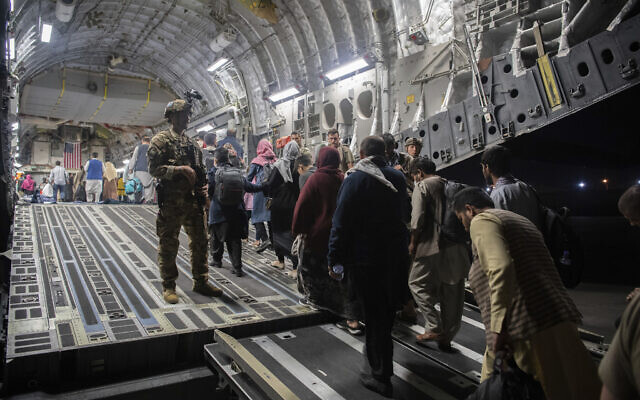 In this August 22, 2021, file photo provided by the US Air Force, Afghan passengers board a US Air Force C-17 Globemaster III during the Afghanistan evacuation at Hamid Karzai International Airport in Kabul, Afghanistan. (MSgt. Donald R. Allen/US Air Force via AP, File)