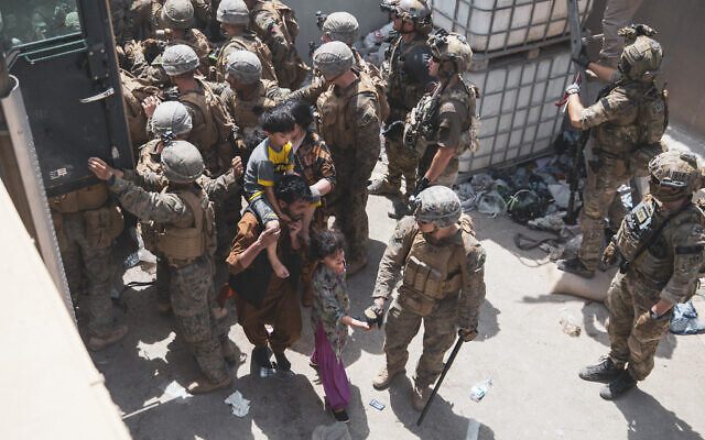 In this August 20, 2021, file photo provided by the US Marine Corps, US Marines and Norwegian coalition forces assist with security at an Evacuation Control Checkpoint ensuring evacuees are processed safely during an evacuation at Hamid Karzai International Airport in Kabul, Afghanistan. (Staff Sgt. Victor Mancilla/US Marine Corps via AP, File)
