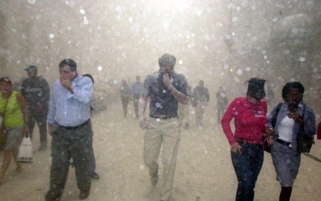 People run from the collapse of World Trade Center towers in New York, Tuesday, Sept. 11, 2001 after terrorists crashed two hijacked airliners into the World Trade Center and brought down the twin 110-story towers. (AP Photo/Suzanne Plunkett)