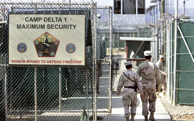 In this June 27, 2006 file photo, reviewed by a US Department of Defense official, US military guards walk within Camp Delta military-run prison, at the Guantanamo Bay US Naval Base, Cuba. (AP/Brennan Linsley, File)