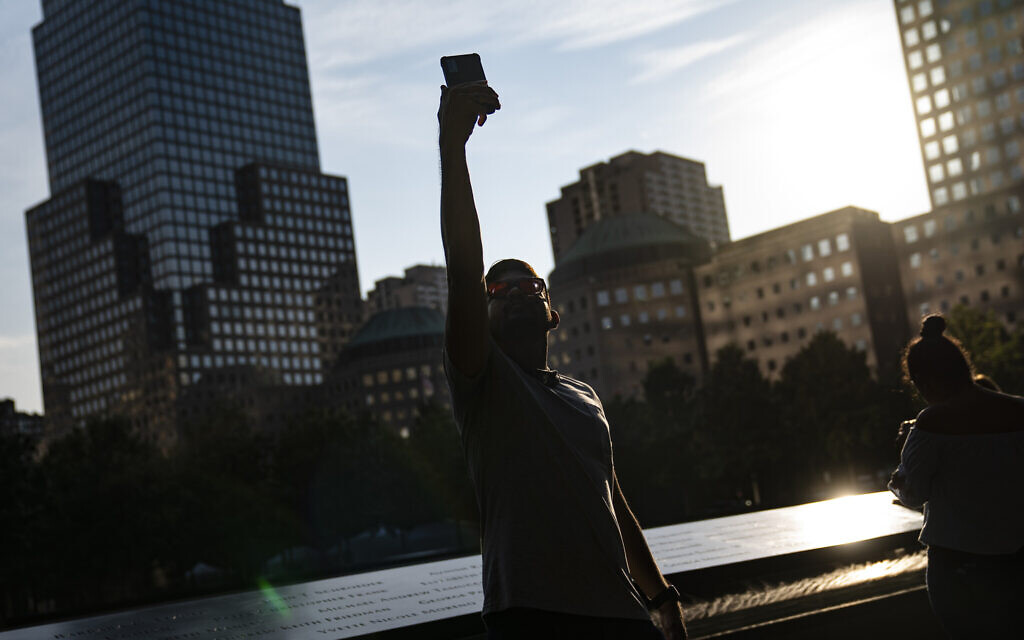 A visitor takes a selfie beside the north pool at the National September 11 Memorial & Museum, Wednesday, Sept. 8, 2021, in New York. (AP Photo/John Minchillo)