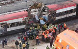 In this March 11, 2004 file photo rescue workers cover up bodies alongside a bomb-damaged passenger train, following a number of explosions in Madrid, Spain, March 11, 2004. (AP Photo/Paul White, File)