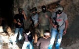 In this photo provided by Israel Police, Israeli security forces stand next to escaped Palestinian security prisoners Zakaria Zubeidi (left) and Mohammed al-Arida, blindfolded and handcuffed after being recaptured in the northern Arab town of Shibli–Umm al-Ghanam, on September 11, 2021. (Israel Police)