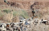 Israeli soldiers take positions along the border between the northern West Bank near Jenin and Israel as they search for two Palestinians who broke out of a maximum-security prison last week, on a road leading to the West Bank town of Jenin, near Gan Ner Israel, September 12, 2021. (AP/Ariel Schalit)