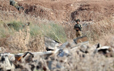 Israeli soldiers take positions along the border between the northern West Bank near Jenin and Israel as they search for two Palestinians who broke out of a maximum-security prison last week, on a road leading to the West Bank town of Jenin, near Gan Ner Israel, September 12, 2021. (AP/Ariel Schalit)