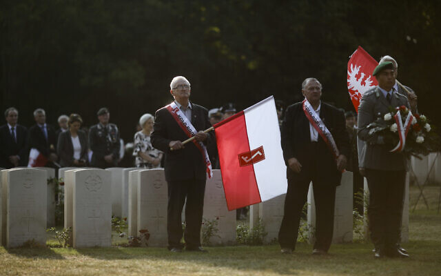People with Polish flags attend a wreath laying ceremony to commemorate the Nazi German invasion of Poland and the beginning of World War II at the British War Cemetery in Berlin, Germany, September 1, 2019. (AP Photo/Markus Schreiber, File) People with Polish flags attend a wreath laying ceremony to commemorate the Nazi German invasion of Poland and the beginning of World War II at the British War Cemetery in Berlin, Germany, September 1, 2019. (AP Photo/Markus Schreiber, File)