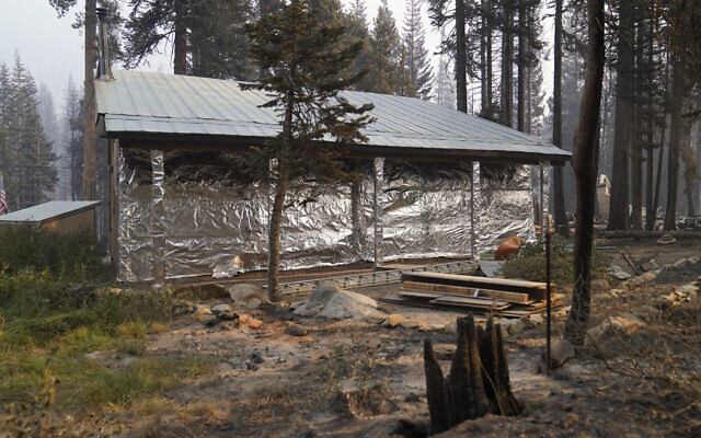 In this September 2, 2021 file photo, cabin partially covered in fire-resistant material stands next to properties destroyed in the Caldor Fire in Twin Bridges, CA. (AP/Jae C. Hong,File) In this September 2, 2021 file photo, cabin partially covered in fire-resistant material stands next to properties destroyed in the Caldor Fire in Twin Bridges, CA. (AP/Jae C. Hong,File)